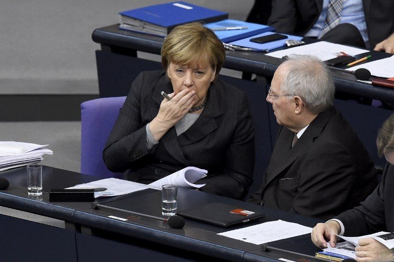 German Chancellor Angela Merkel (L) chats with German Finance Minister Wolfgang Schaeuble during a plenary session of the German lower house of parliament Bundestag before deputies vote on a stepped-up German role in the fight against the Islamic State group in Berlin December 4, 2015. The mandate would cover six Tornado reconnaissance jets, one refuelling aircraft, a naval frigate and up to 1,200 troops following a request from France after the November 13 jihadist attacks. AFP PHOTO / TOBIAS SCHWARZ / AFP / TOBIAS SCHWARZ