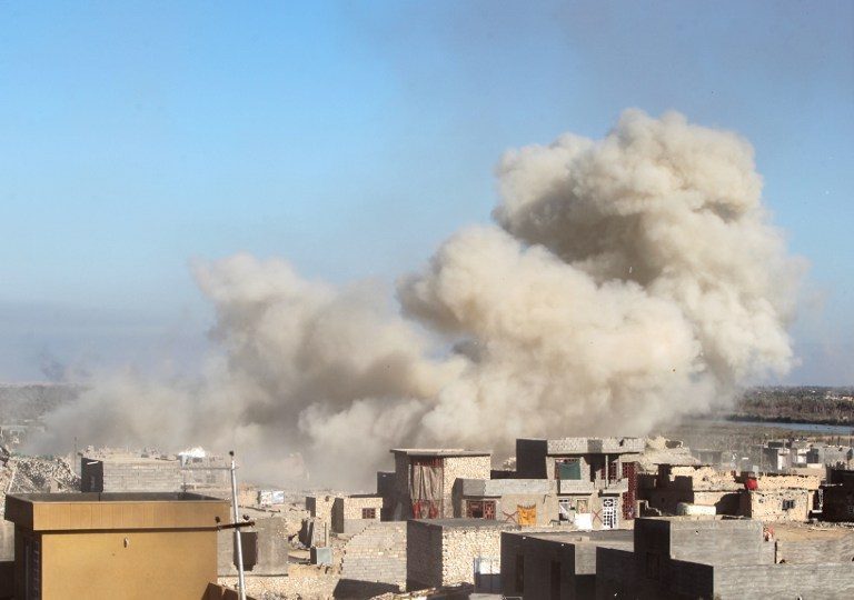 A picture taken on December 7, 2015 shows smoke billowing in the rural town of Husayba, in the Euphrates Valley seven kilometres (4.5 miles) east of Ramadi, where Iraqi government forces have been closing on Islamic State (IS) group militants who seized the Anbar province's capital in May after a three-day blitz involving dozens of huge truck bombs. Iraqi security forces have fought their way to the outskirts of Ramadi, where they have been battling the IS jihadists in the past weeks. AFP PHOTO / AHMAD AL-RUBAYE / AFP / AHMAD AL-RUBAYE