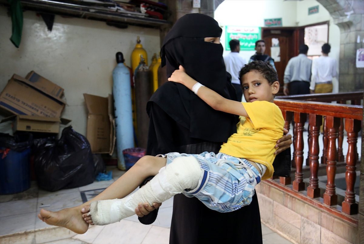 Woman carries a boy, who has been injured, to es-Sevra hospital, in Taiz,Yemen on June 4, 2016.