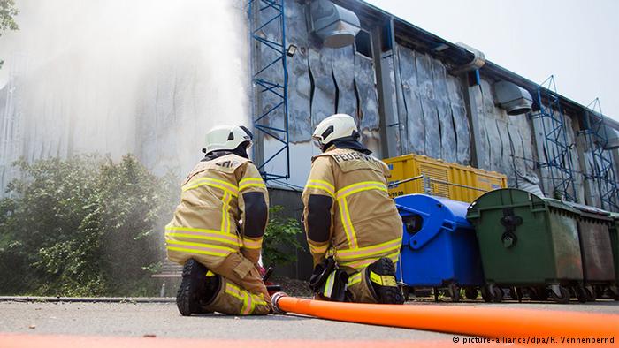 Firefighters extinguish a fire at a shelter for asylum seekers in Düsseldorf
