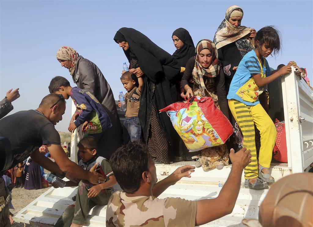 Iraqi soldiers help families from a vehicle outside an Iraqi army military camp near Fallujah, on June 3