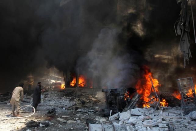 Men try to put out a fire at a market hit by air strikes in Idlib city
