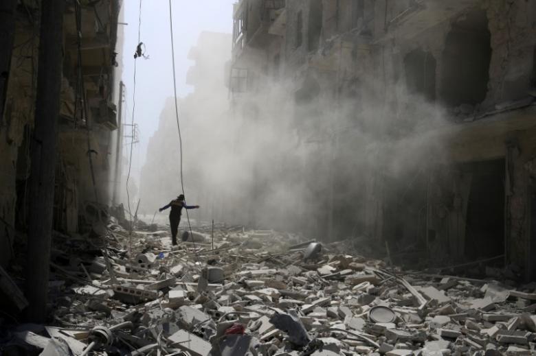 A man walks on the rubble of damaged buildings after an airstrike on the rebel held al-Qaterji neighbourhood of Aleppo, Syria September 25, 2016. REUTERS/Abdalrhman Ismail